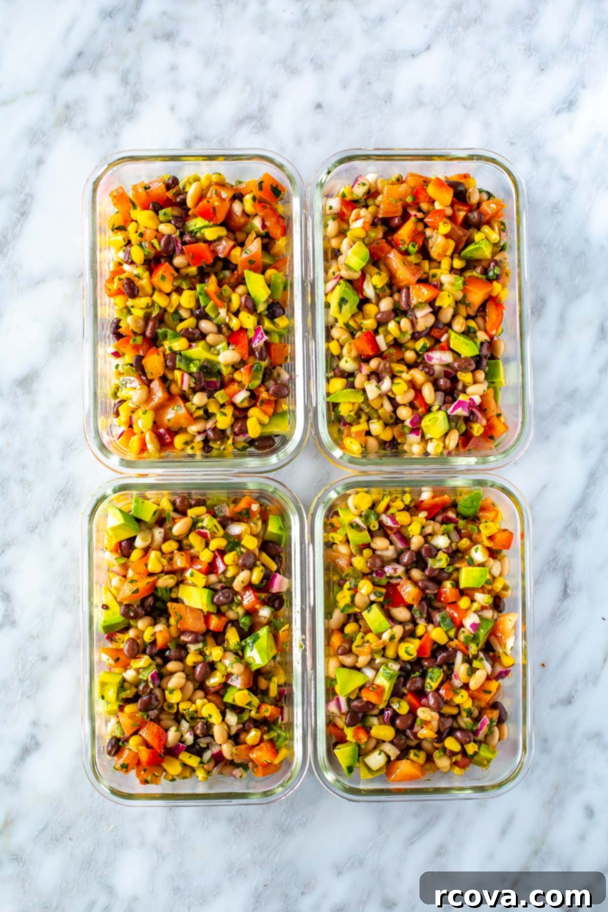 The Only Cowboy Caviar Recipe You'll Ever Need 8 Four meal prep containers filled with vibrant cowboy caviar, ready for healthy lunches.