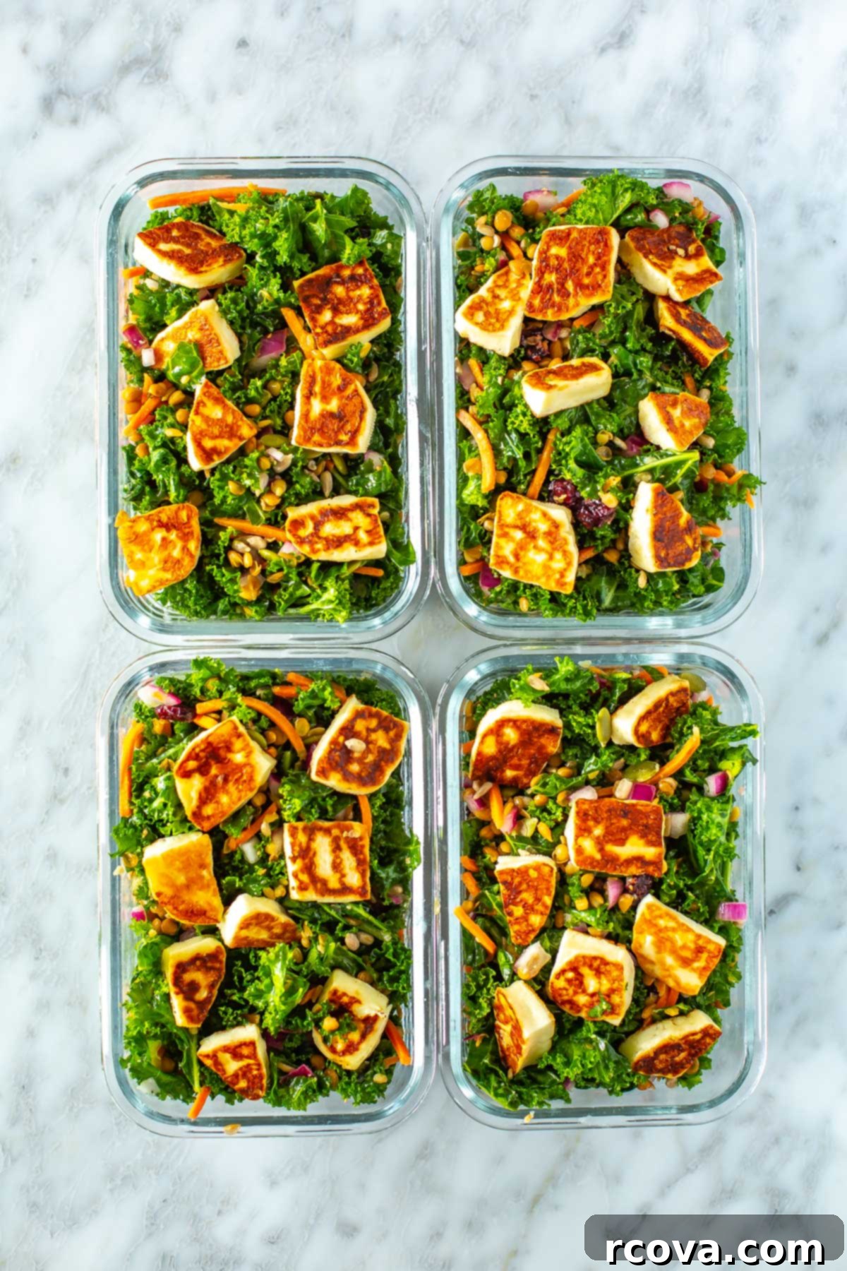 Viral Kale Salad Sensation 8 Four individual meal prep containers, each filled with a vibrant kale salad topped with golden-brown halloumi cheese, ready for healthy and convenient meals throughout the week.