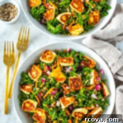 Viral Kale Salad Sensation 9 Two bowls filled with kale salad topped with cooked halloumi cheese.