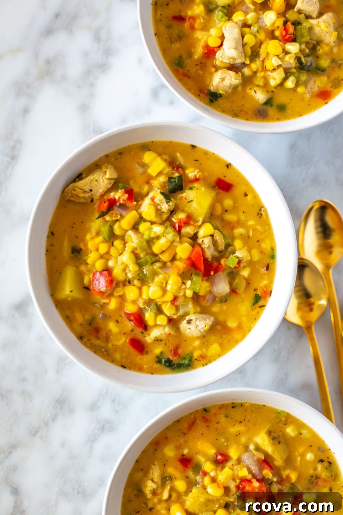 19 Wholesome and Flavorful Corn Creations 5 Three bowls each filled with healthy chicken corn chowder, garnished with fresh herbs.