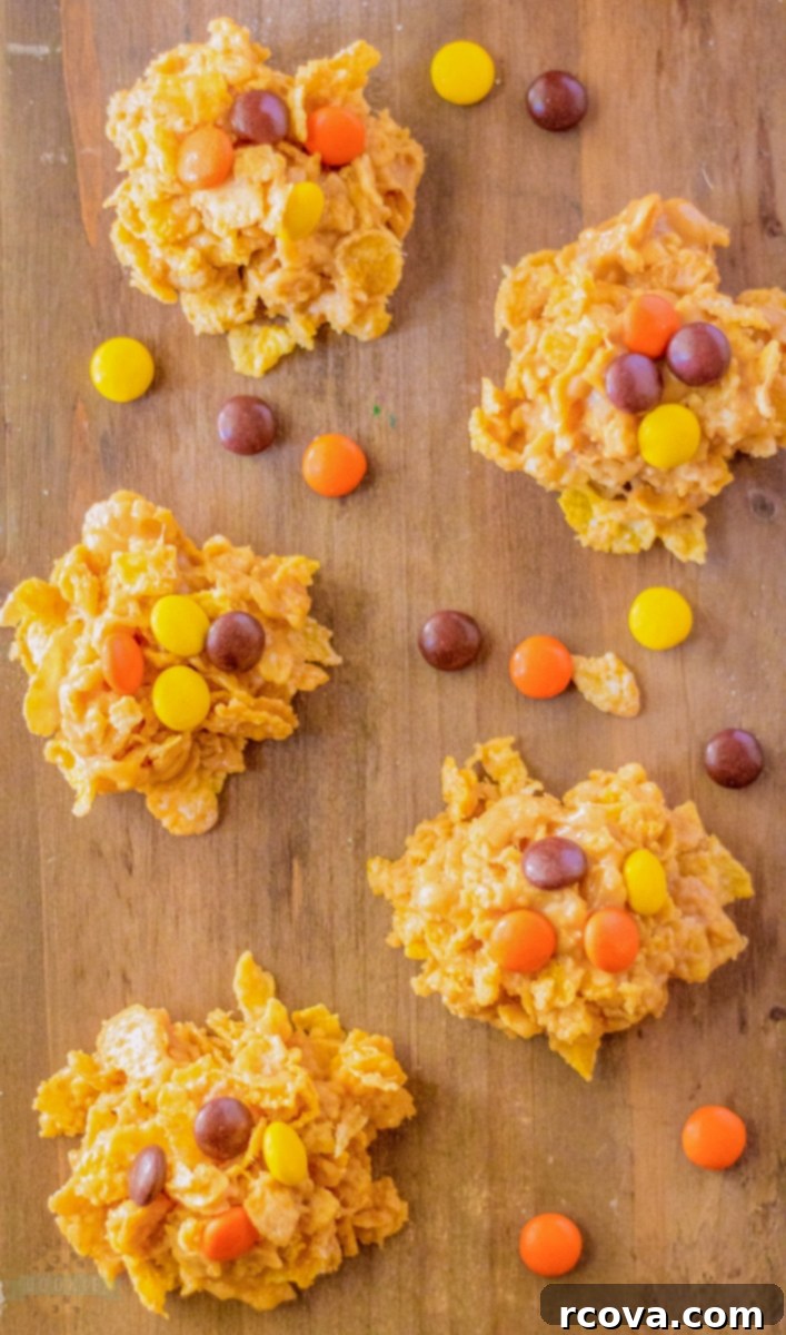 Reeses Cornflake Peanut Butter Crunch Cookies 4 Rustic wooden board showcasing perfectly formed cornflake no-bake cookies, some topped with Reese's Pieces