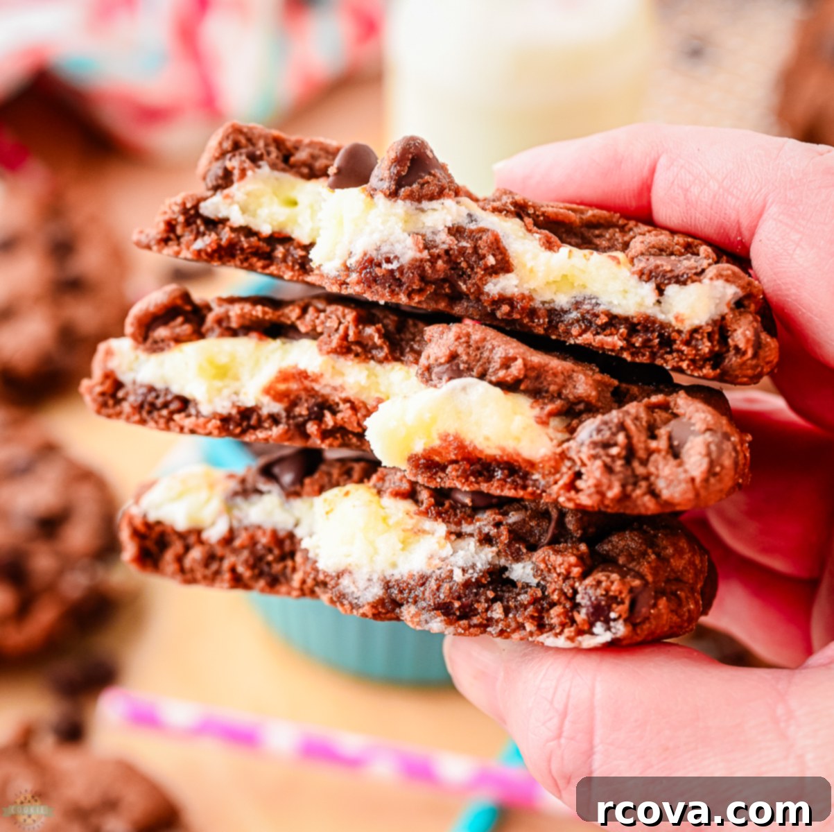 Lush Chocolate Cream Cheese Cookies 4 Three cream cheese and chocolate cookies broken in half, showcasing the creamy filling