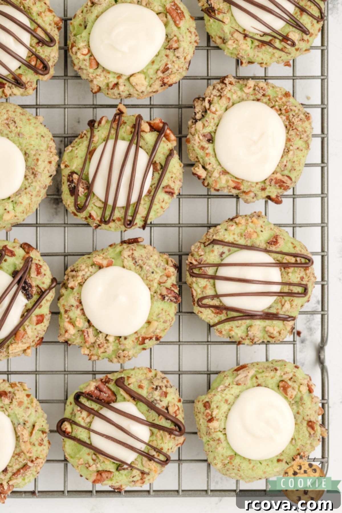 Pistachio Thumbprint Delights 8 Pistachio Thumbprint Cookies on a wire rack.