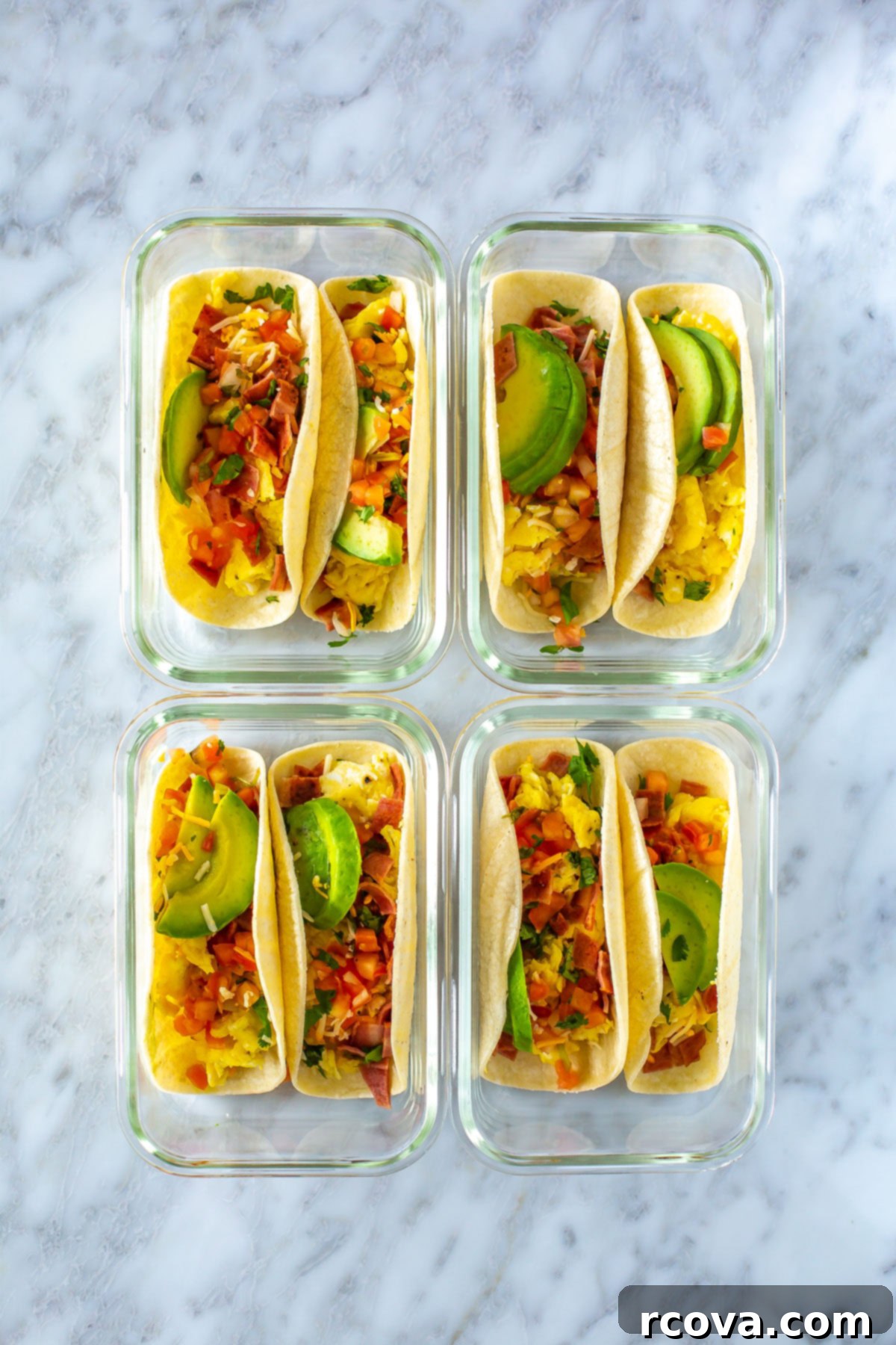 The Ultimate 30-Minute Breakfast Tacos 8 Four perfectly portioned meal prep containers, each holding two delicious breakfast tacos, illustrating an organized and healthy meal preparation strategy.