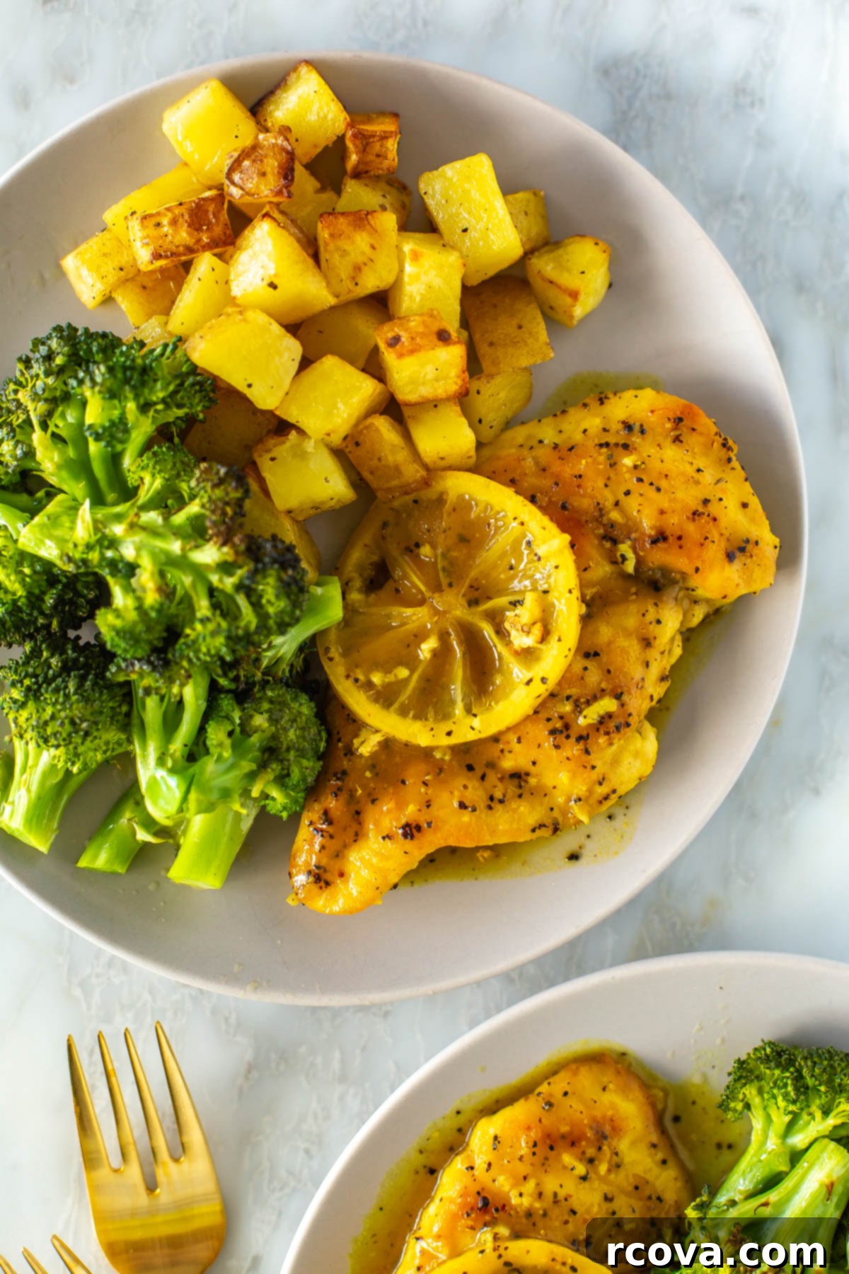 Tangy & Tender Lemon Pepper Chicken 8 A close-up of a plate with lemon pepper chicken with a side of roasted potatoes and roasted broccoli.