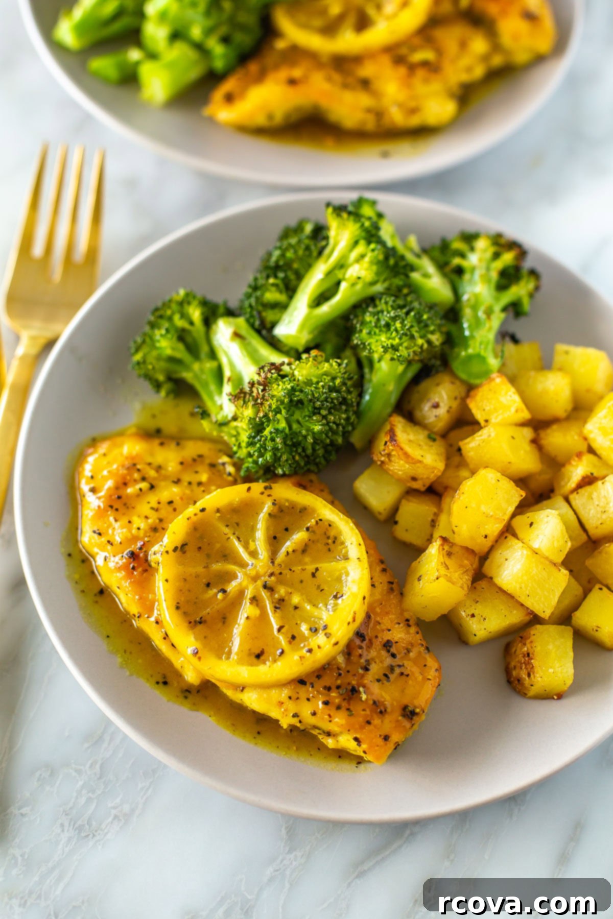 Tangy & Tender Lemon Pepper Chicken 9 A close-up of a plate with lemon pepper chicken with a side of roasted potatoes and roasted broccoli.
