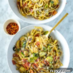 Bacon Brussels Sprouts Creamy Pasta 9 Two bowls of creamy brussels sprouts pasta garnished with a little bowl of chili flakes places beside them.