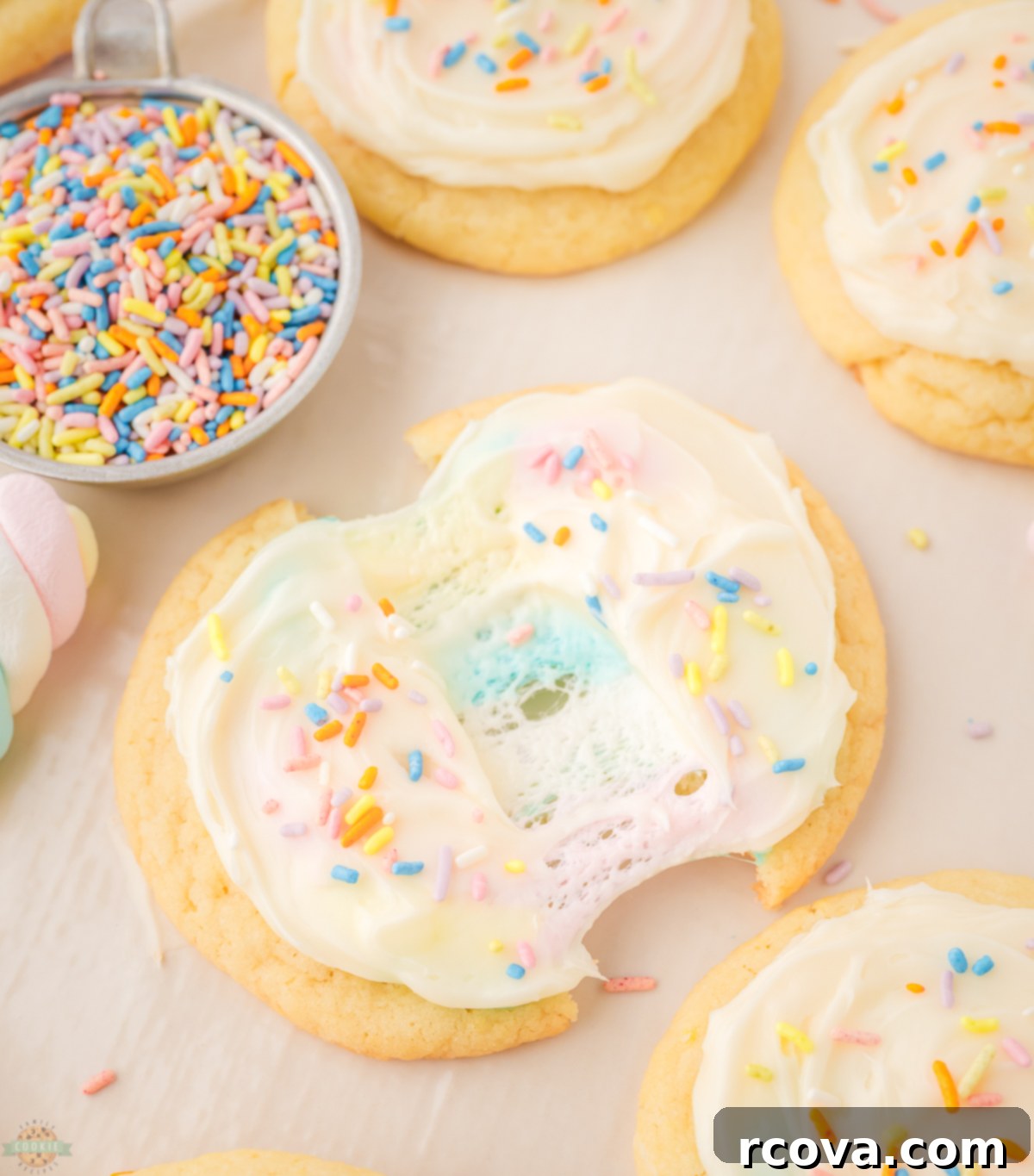 Gooey Marshmallow-Stuffed Cookies 6 Marshmallow Surprise Cookies with frosting and sprinkles on a cooling rack