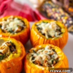 Unutulmaz Balkabağı Dolması Tarifi 11 Four stuffed mini pumpkins in the foreground on a platter with fall decor in the background.