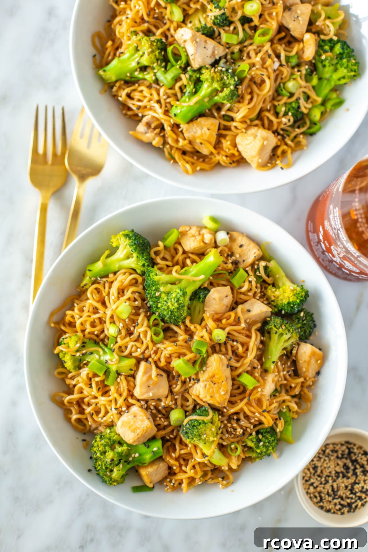 Effortless 30-Minute Chicken Ramen Stir Fry 2 Two bowls of chicken ramen stir fry topped with sesame seeds, ready to be served.