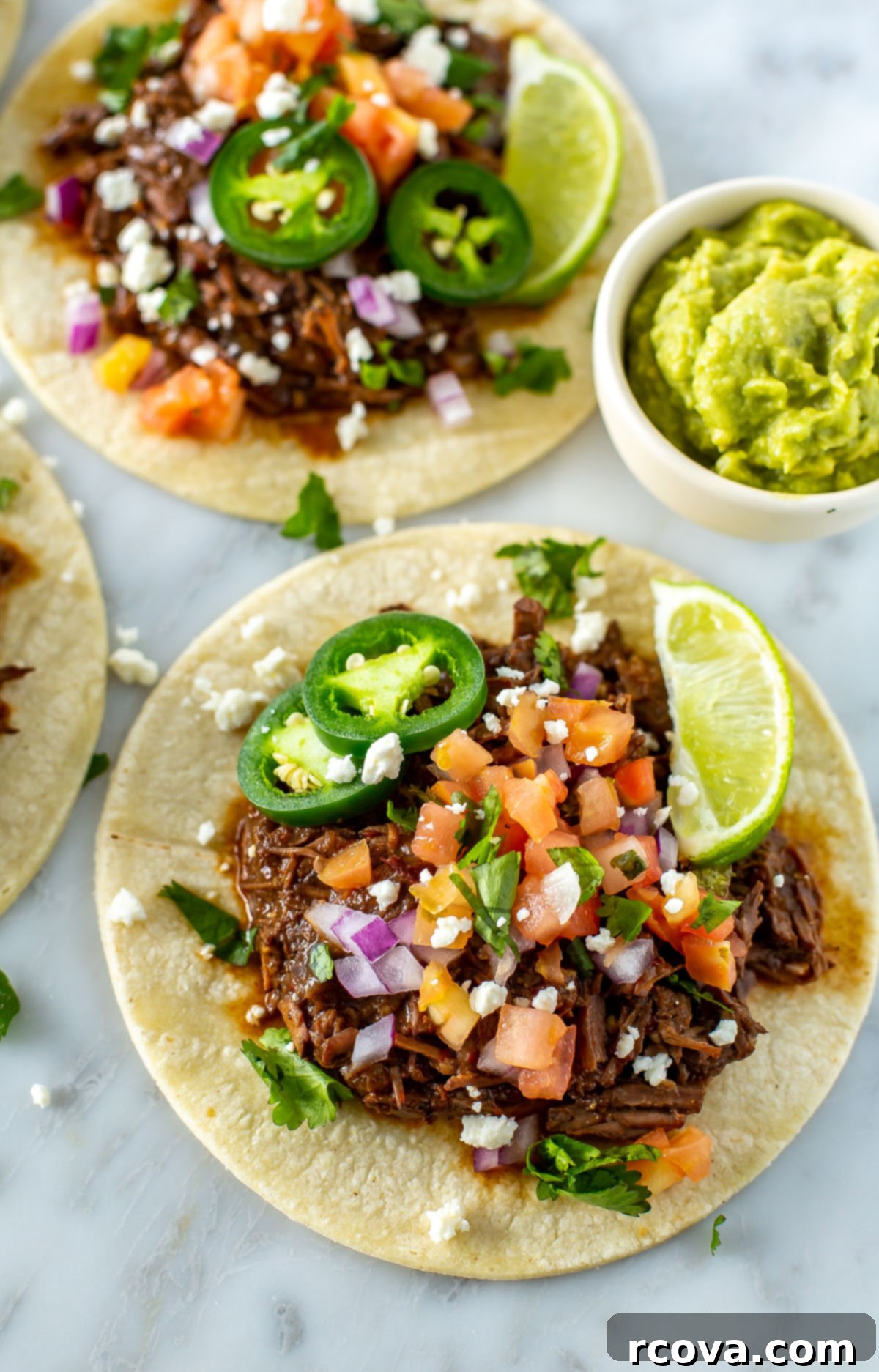 Crockpot Stovetop or Instant Pot Shredded Beef Tacos 8 A close-up shot of a shredded beef taco with a variety of toppings on it.