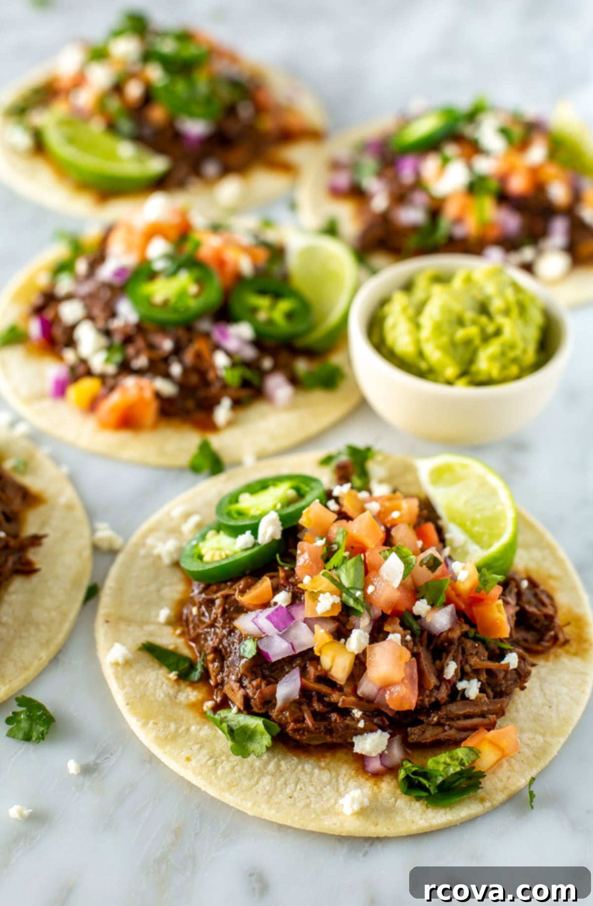 Crockpot Stovetop or Instant Pot Shredded Beef Tacos 9 Four shredded beef tacos with a cup of guacamole on the side.