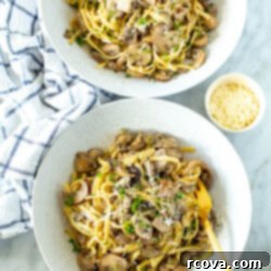 Velvety One-Pot Mushroom Pasta 10 Two bowls of creamy mushroom pasta with a small bowl of parmesan cheese on the side.