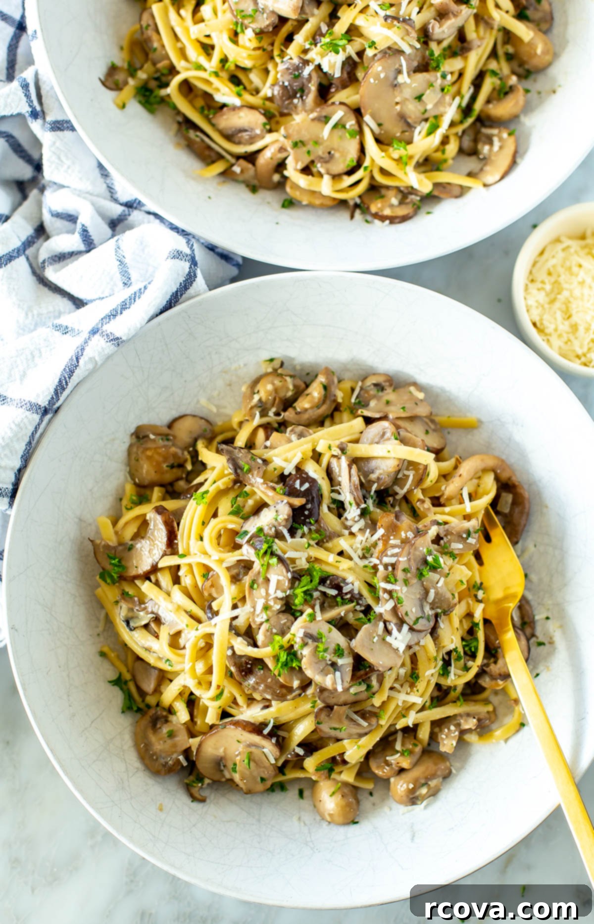 Velvety One-Pot Mushroom Pasta 7 A mesmerizing close-up overhead shot of a single bowl of steaming, creamy mushroom pasta, adorned with vibrant fresh parsley and a generous sprinkle of parmesan cheese, highlighting the rich, smooth texture of the sauce and the perfectly cooked mushrooms.