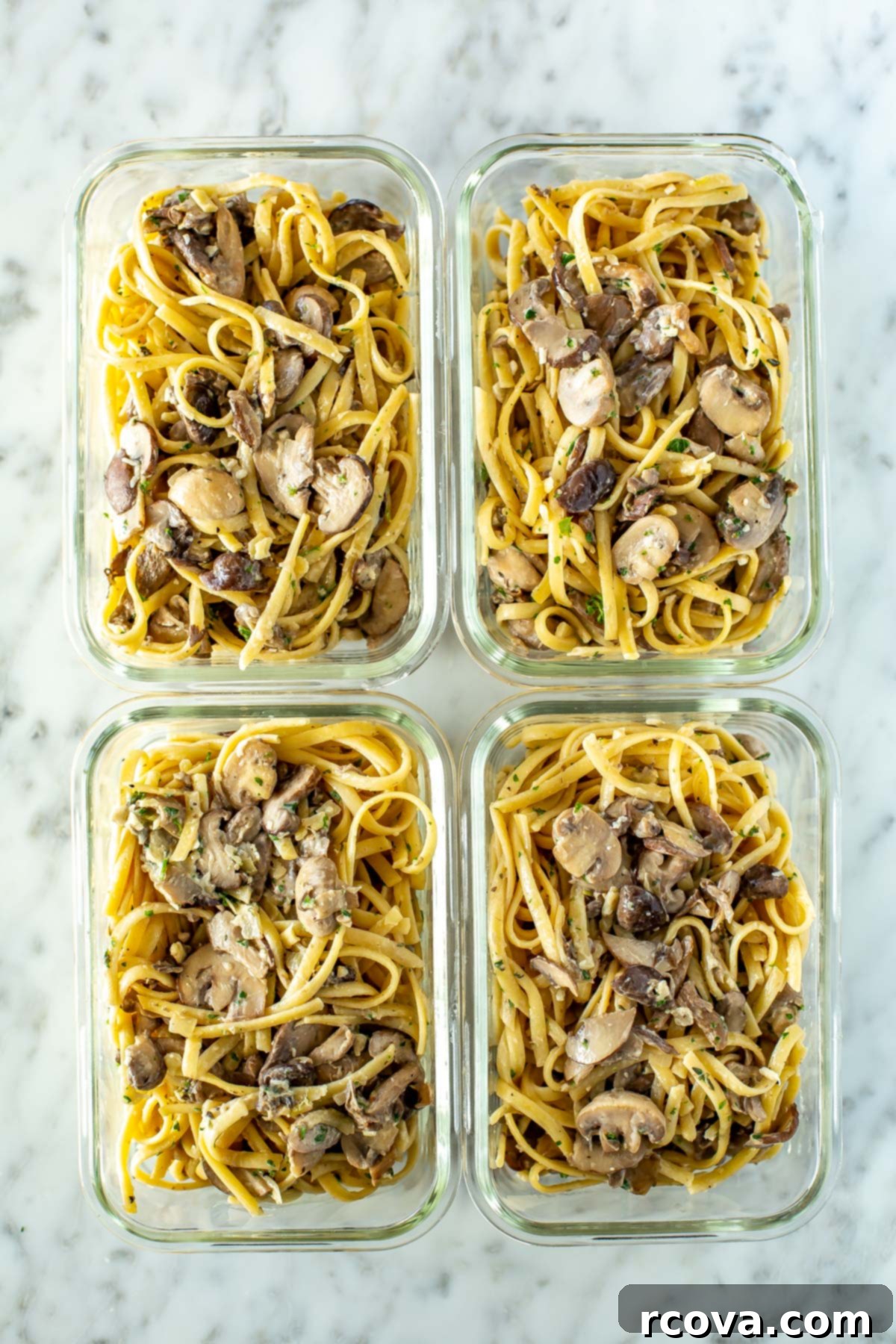 Velvety One-Pot Mushroom Pasta 9 Four perfectly portioned glass meal prep containers, each neatly filled with a serving of creamy mushroom pasta, ready for storage or future convenient meals.