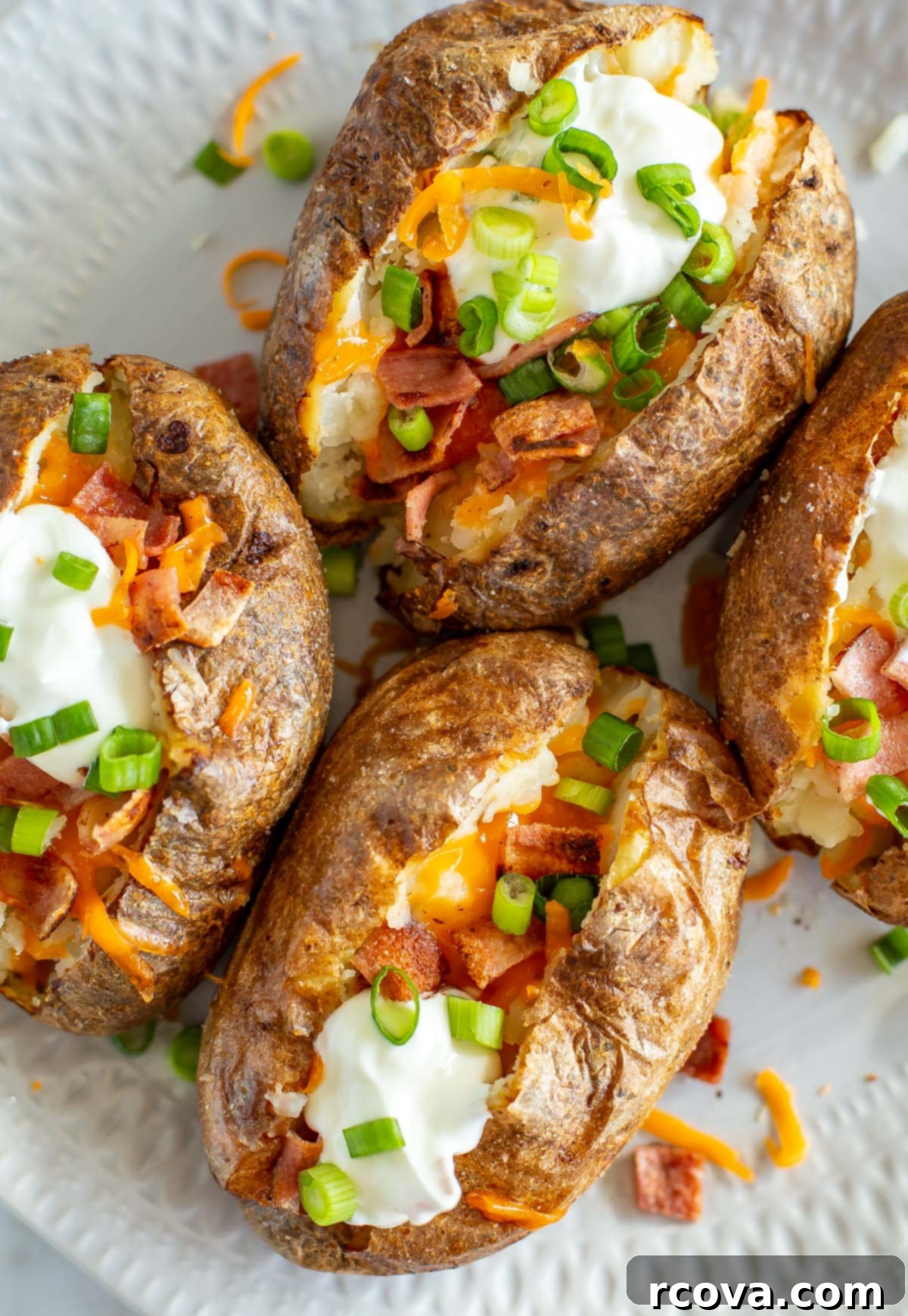 The Ultimate Fully Loaded Air Fryer Baked Potato 9 Another close-up of fully loaded air fryer baked potatoes on a plate, emphasizing the rich, savory toppings and fluffy potato.