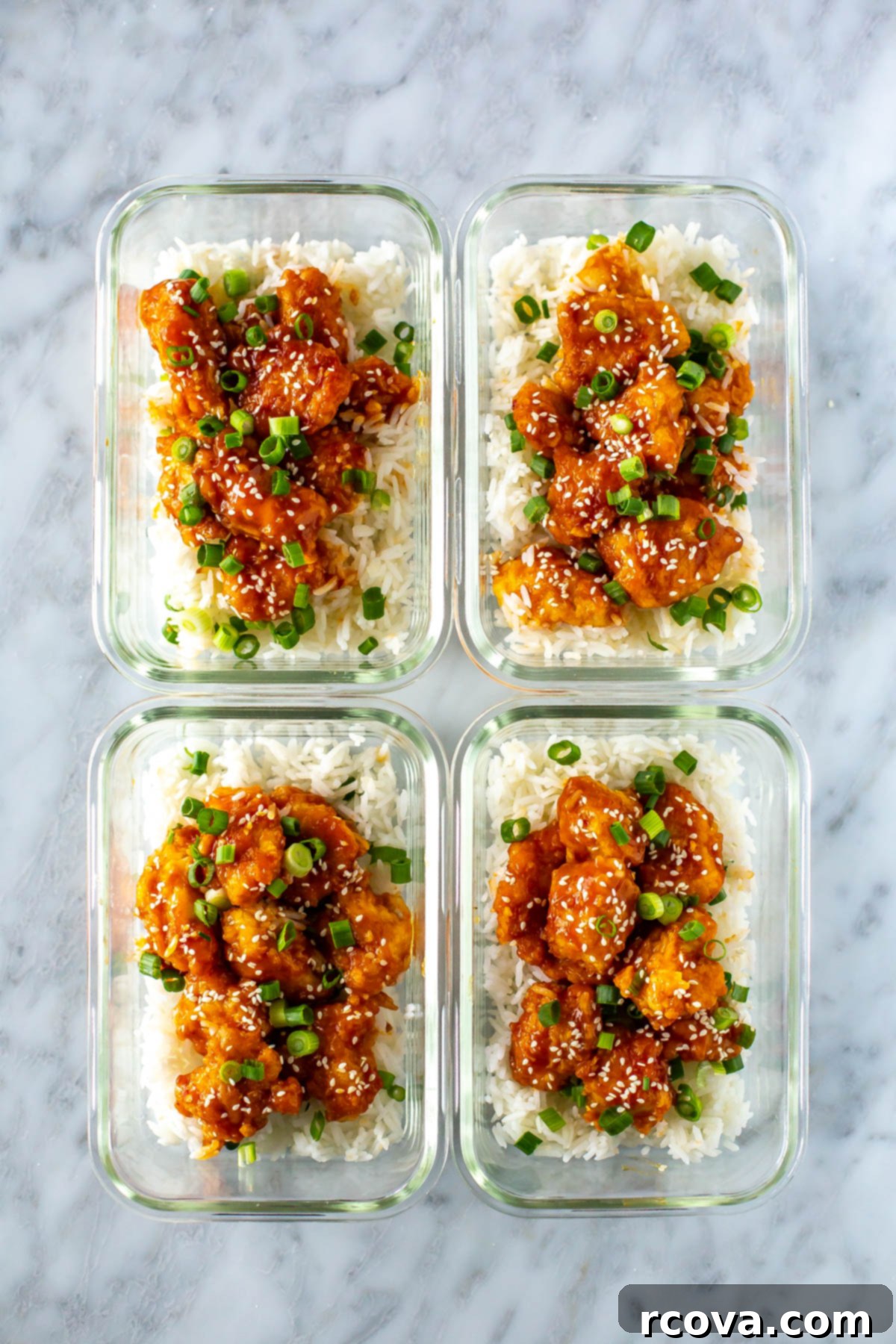 Quick Mandarin Chicken Delight 10 Four glass meal prep containers, each filled with fluffy white rice and topped with generous portions of crispy Mandarin chicken, garnished with green onions and sesame seeds.
