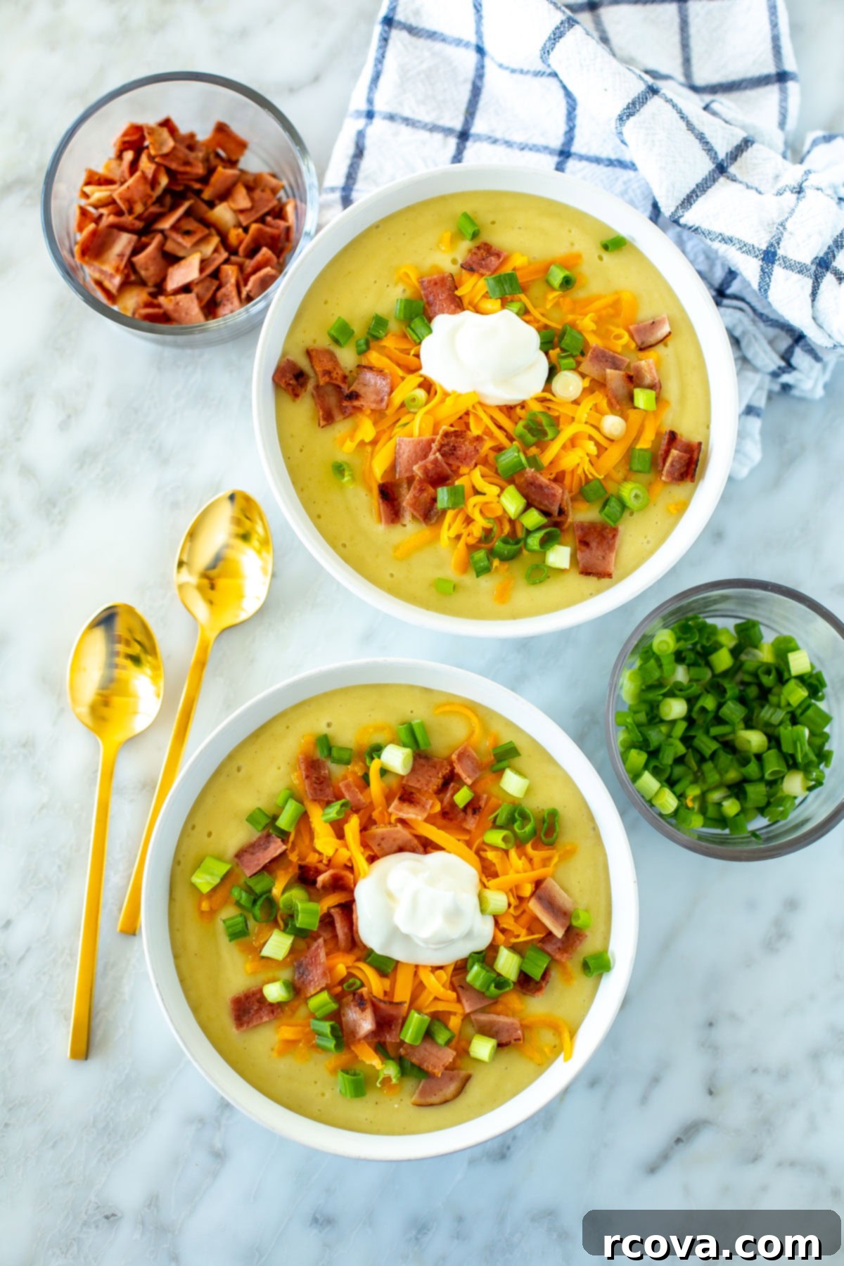 Your New Favorite Slow Cooker Potato Soup 2 Two bowls of crockpot potato soup topped with cheddar cheese, crispy bacon bits, fresh green onions, and a swirl of sour cream, ready to be enjoyed on a chilly evening.
