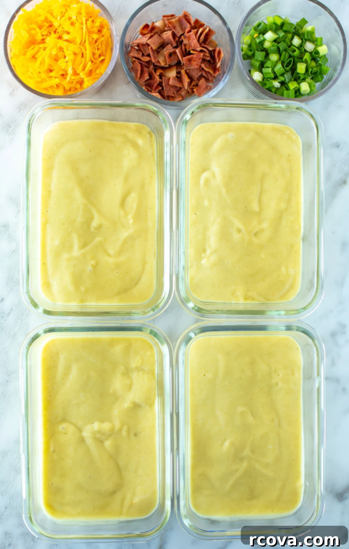 Your New Favorite Slow Cooker Potato Soup 8 Four clear glass meal prep containers, each perfectly filled with a serving of homemade crockpot potato soup, showing organized and ready-to-eat portions.