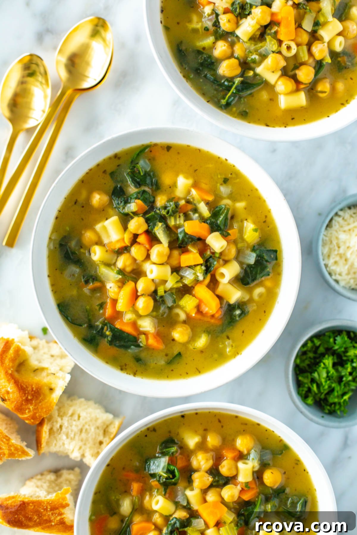 Hearty Chickpea Soup Your Way 8 A close-up of three bowls of chickpea soup with pieces of bread on the side.