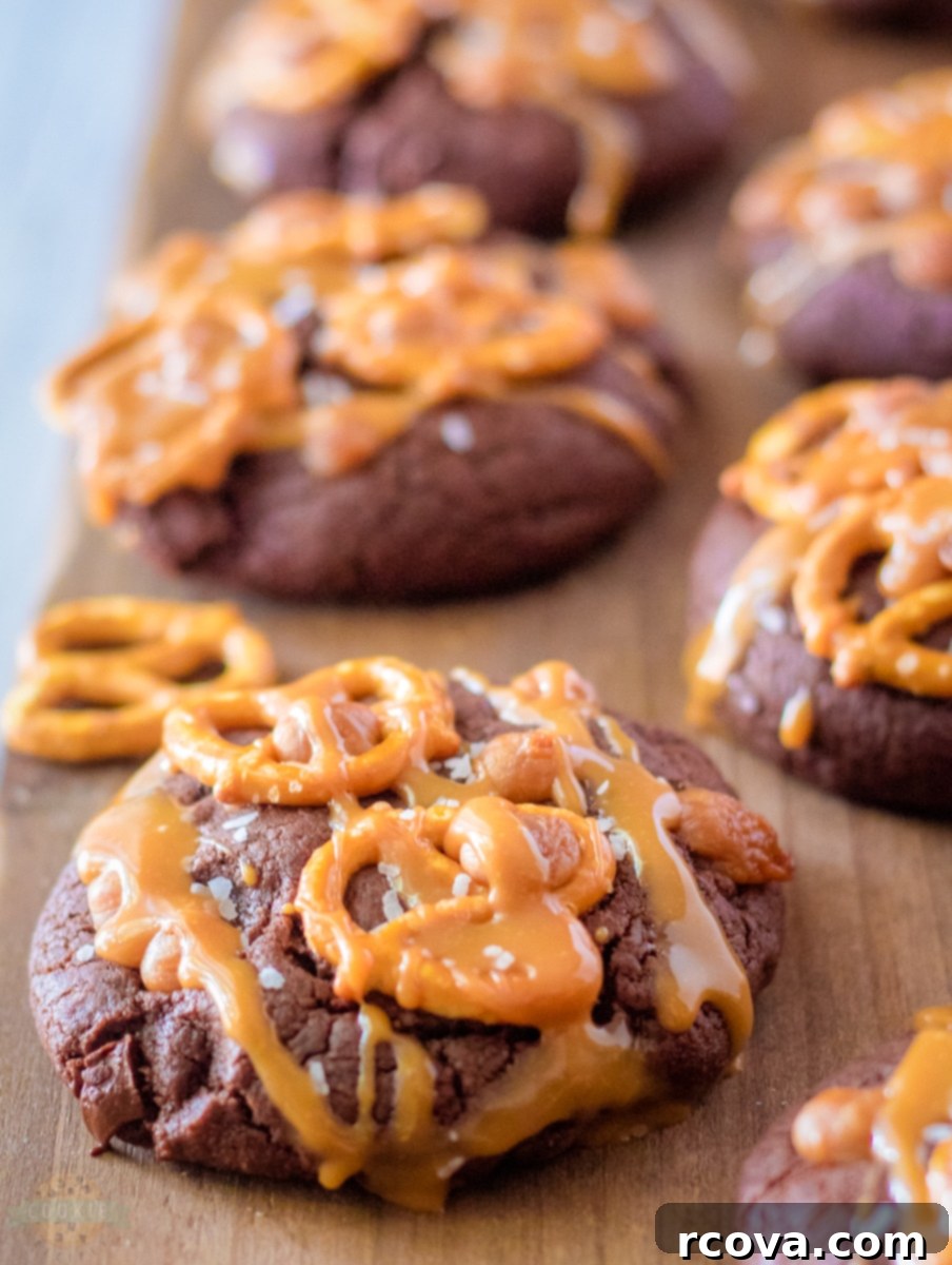 Fudgy Salted Caramel Brownie Cookies 2 Close-up of freshly baked Salted Caramel Brownie Cookies with caramel drizzle and pretzel pieces.