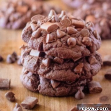 Ultimate Brownie Cookies 7 A close-up of a stack of freshly baked chocolate brownie cookies, highlighting their fudgy texture and visible chocolate chips.