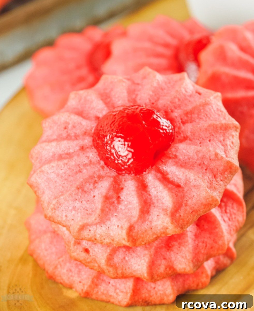 Ruby Cherry Delights 3 A close-up of baked Cherry Jello Cookies with a slight glaze, showcasing their red color and texture.