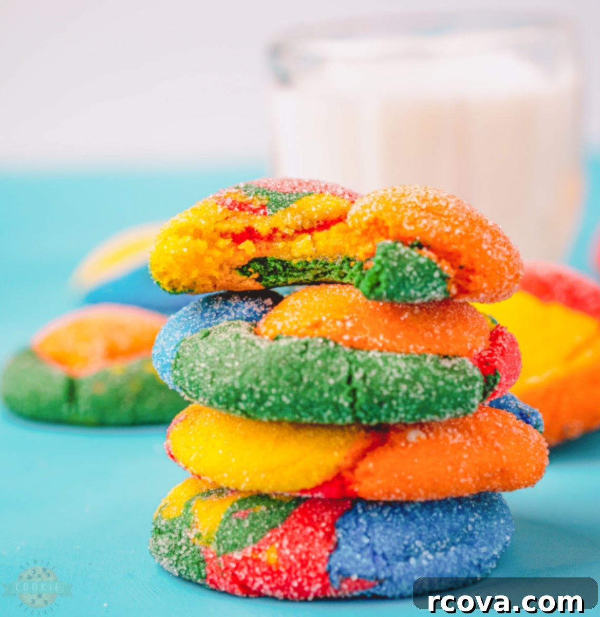 Colorburst Cookies 3 Close-up of a hand placing a freshly baked, colorful cake mix cookie onto a wire cooling rack.