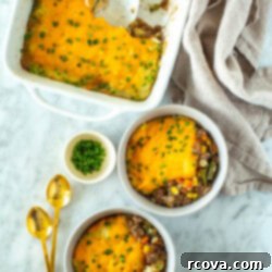 Wholesome Shepherds Delight 11 A casserole dish with classic shepherd's pie with two pieces of it in individual bowls.