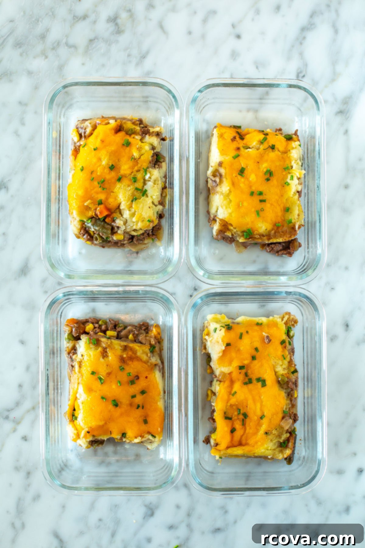 Wholesome Shepherds Delight 10 Four meal prep containers, each with a piece of classic shepherd's pie inside.