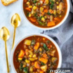 Comforting Crockpot Vegetable Soup 10 Two bowls of crockpot vegetable soup with spoons on the side.