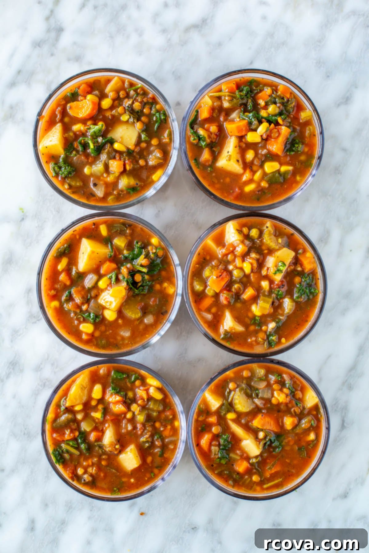 Comforting Crockpot Vegetable Soup 9 Six round glass meal prep containers, each perfectly portioned with delicious crockpot vegetable soup, ready for healthy meals throughout the week.