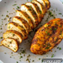 Perfect Air Fryer Chicken Breasts The Ultimate Marinade 10 A plate with one whole air fryer chicken breast and another one that has been sliced.