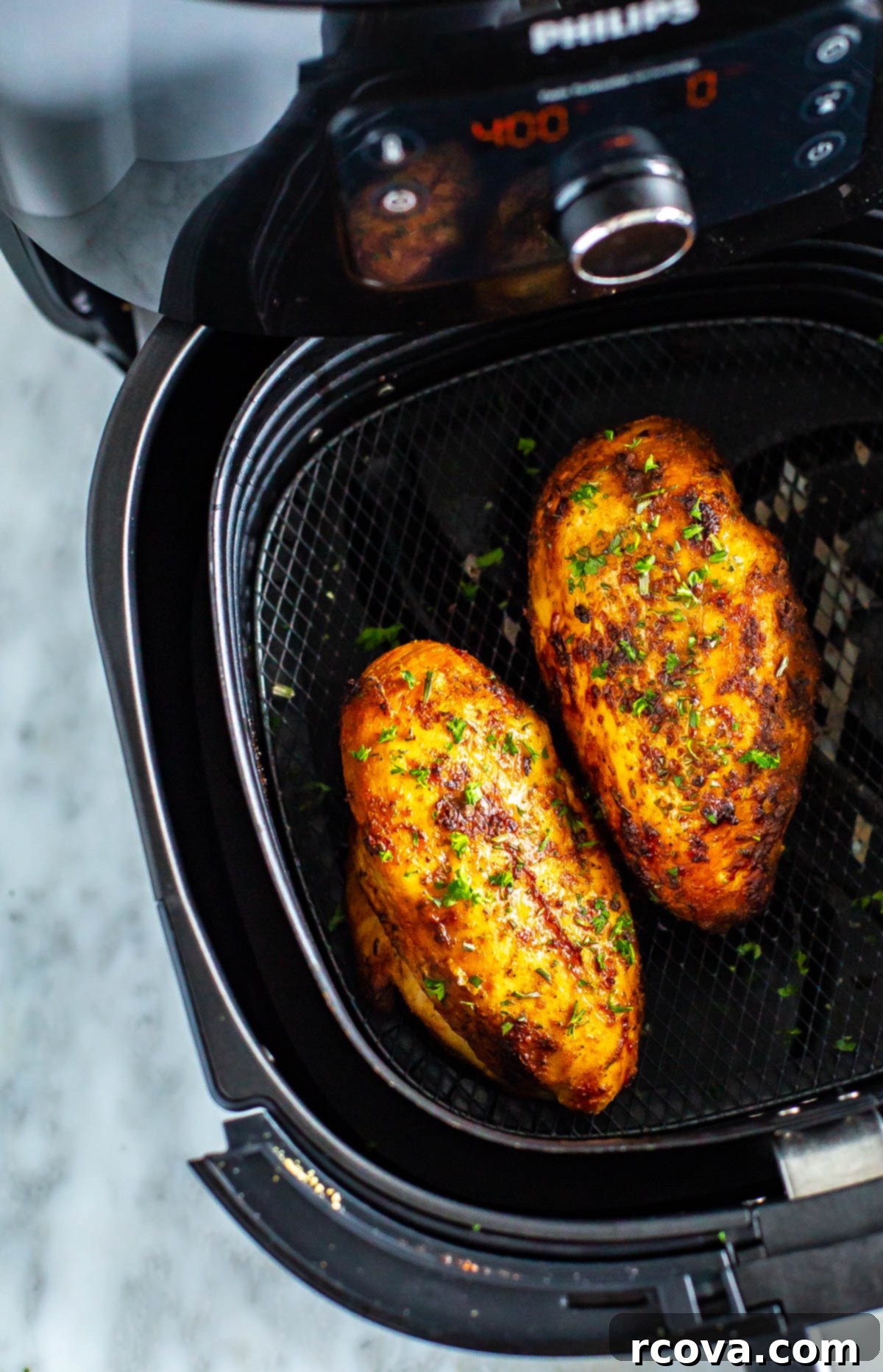 Perfect Air Fryer Chicken Breasts The Ultimate Marinade 8 A close-up of perfectly cooked chicken breasts in an air fryer basket, showing their golden-brown exterior.