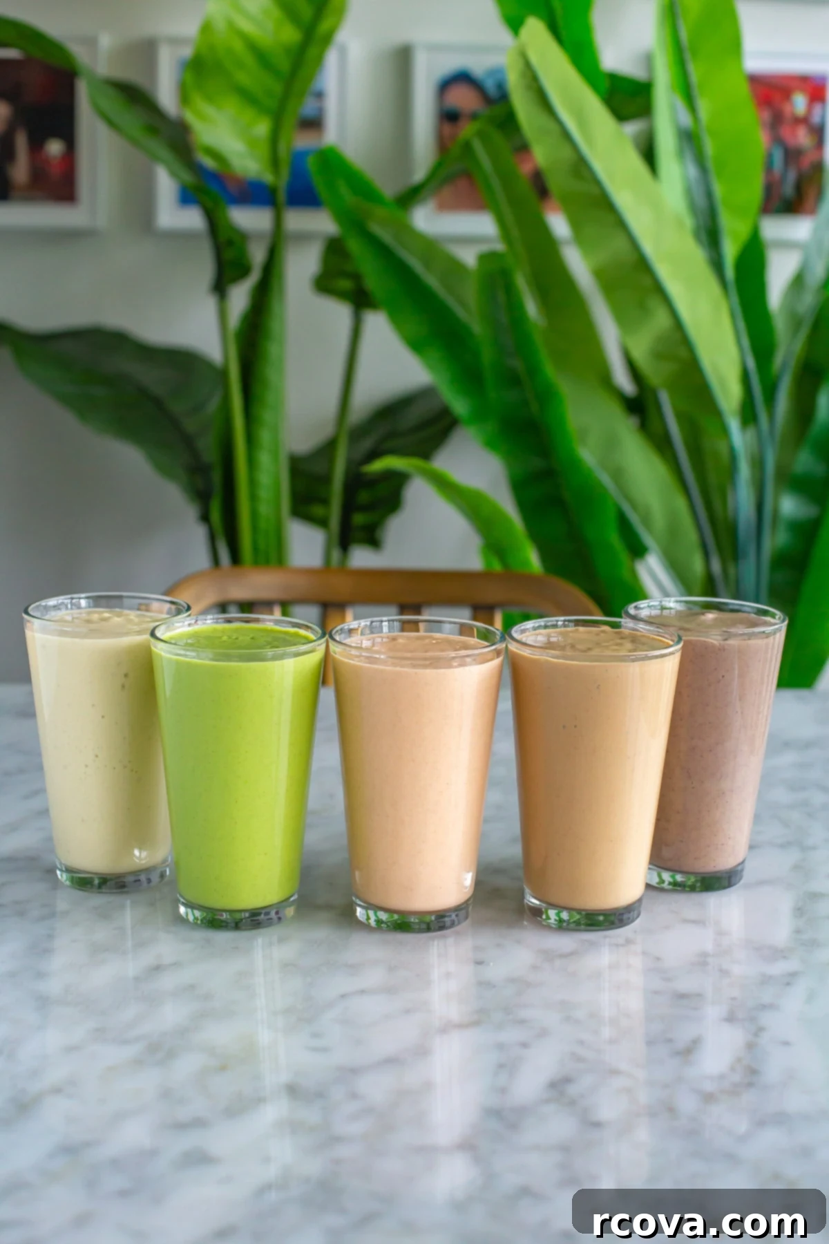 5 Genius Make Ahead Smoothie Packs 13 Five glasses, each beautifully filled with a distinct, freshly blended make-ahead smoothie pack, showcasing a spectrum of colors and creamy textures.