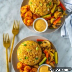 Perfect Benihana Style Hibachi Shrimp 11 Two plates of delicious homemade hibachi shrimp, each with a generous side of creamy yum yum sauce, fried rice, and mixed vegetables.