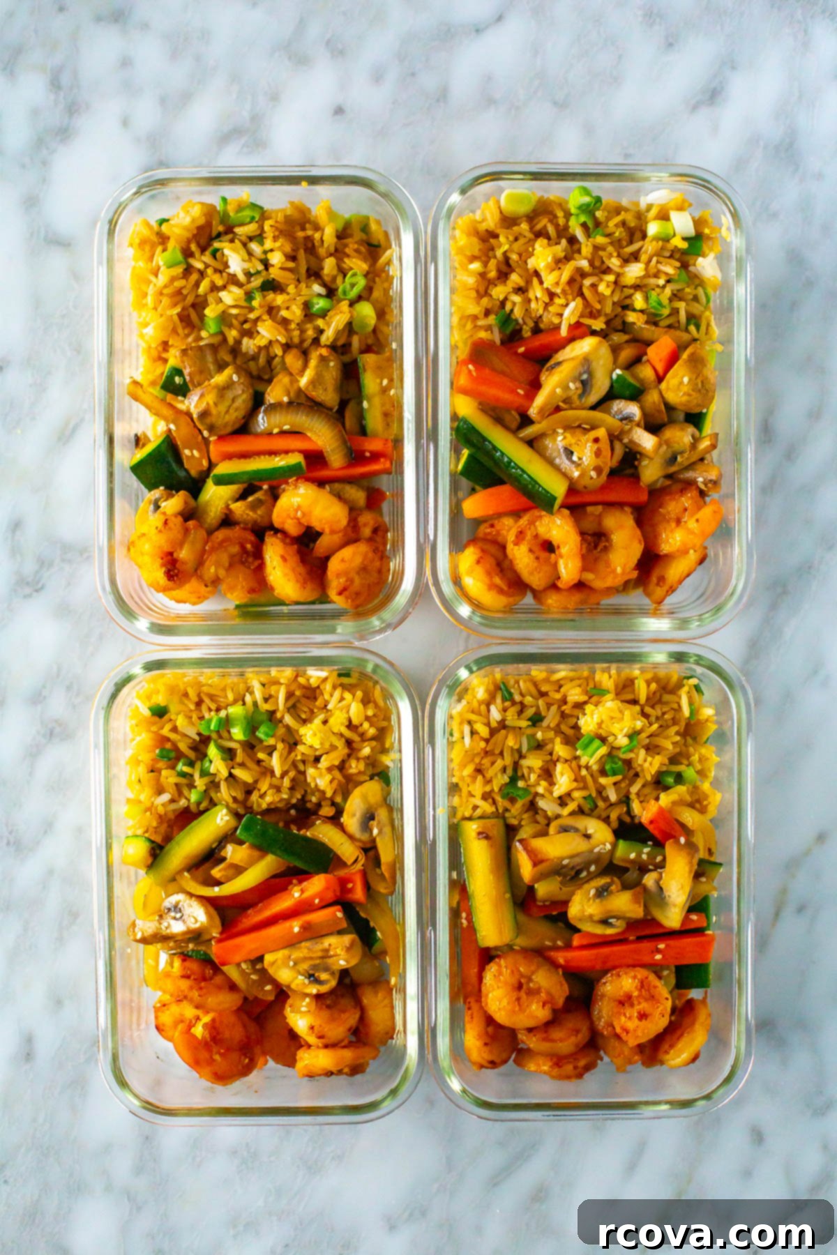 Perfect Benihana Style Hibachi Shrimp 10 Four individual glass meal prep containers, each perfectly portioned with a serving of homemade hibachi shrimp, fried rice, and mixed vegetables, ready for a week of healthy and delicious meals.