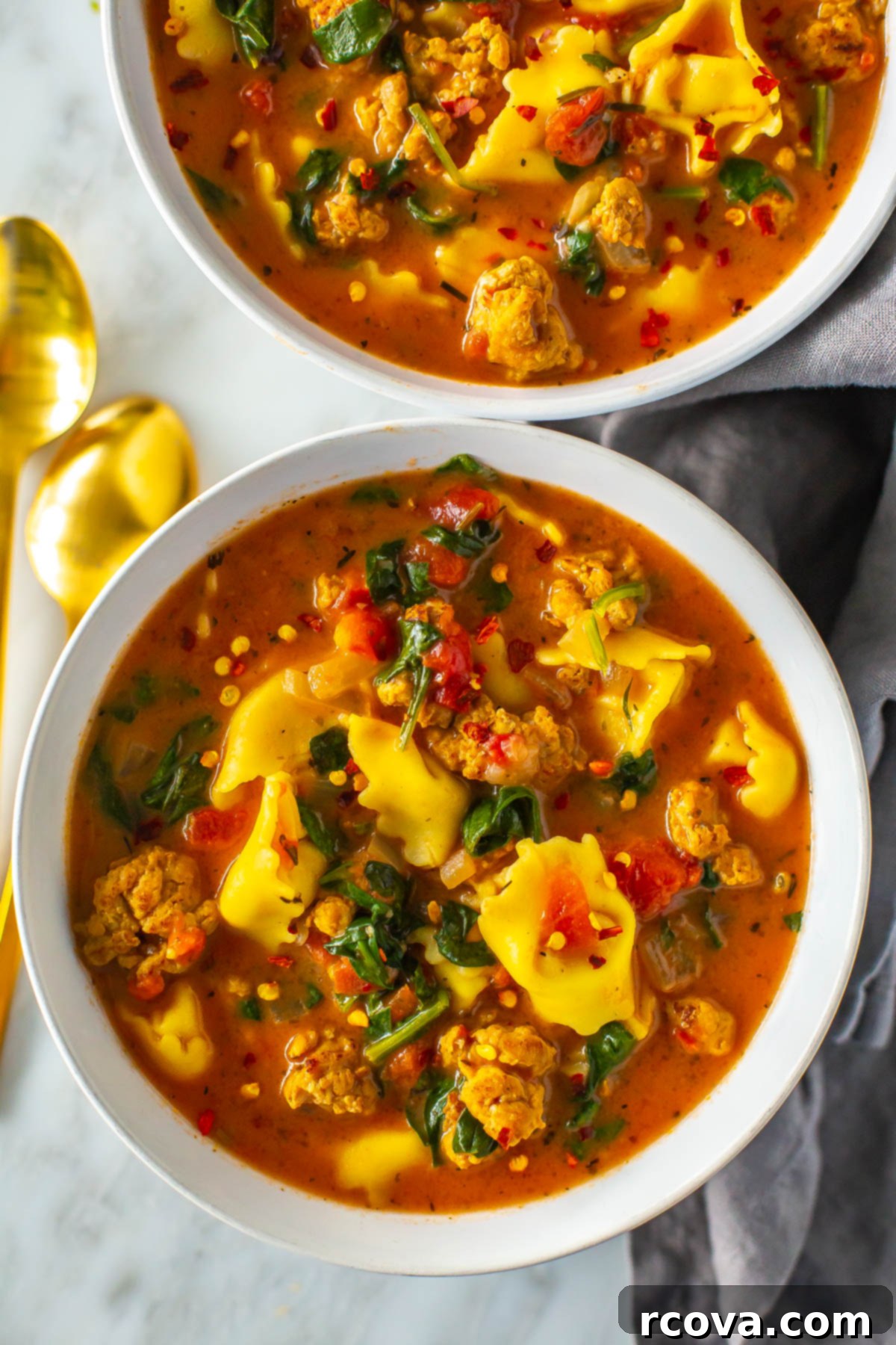 Hearty Crockpot Sausage Tortellini Soup 10 A vibrant, close-up shot of a bowl of creamy crockpot tortellini soup, showcasing the rich broth, tender tortellini, and fresh spinach.