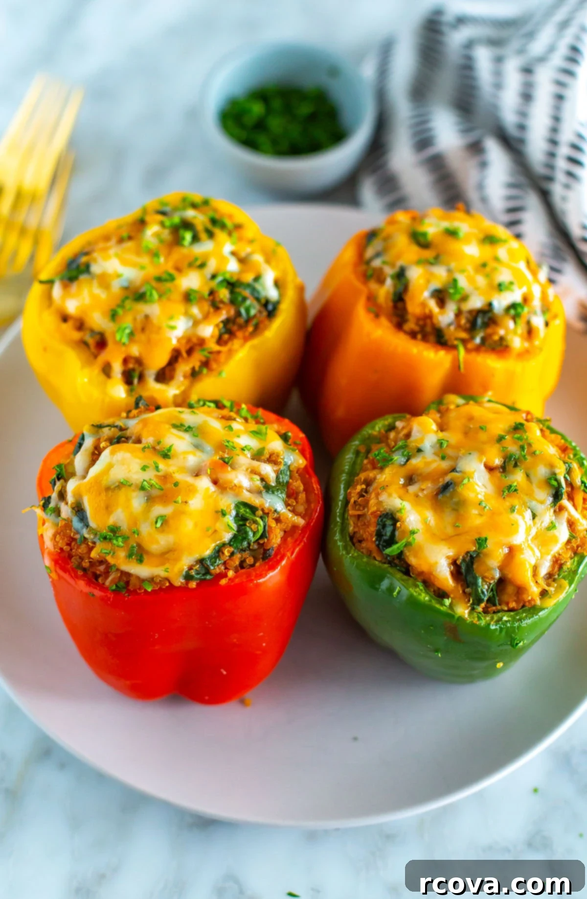 Effortless Air Fryer Stuffed Peppers 8 Four air fryer stuffed peppers on a plate, topped with cheese.