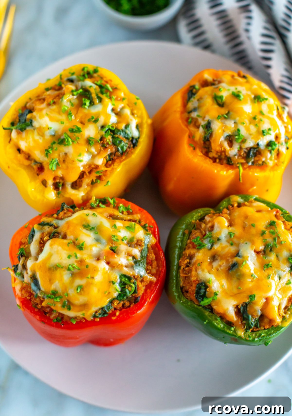 Effortless Air Fryer Stuffed Peppers 10 Four air fryer stuffed peppers on a plate, topped with cheese.