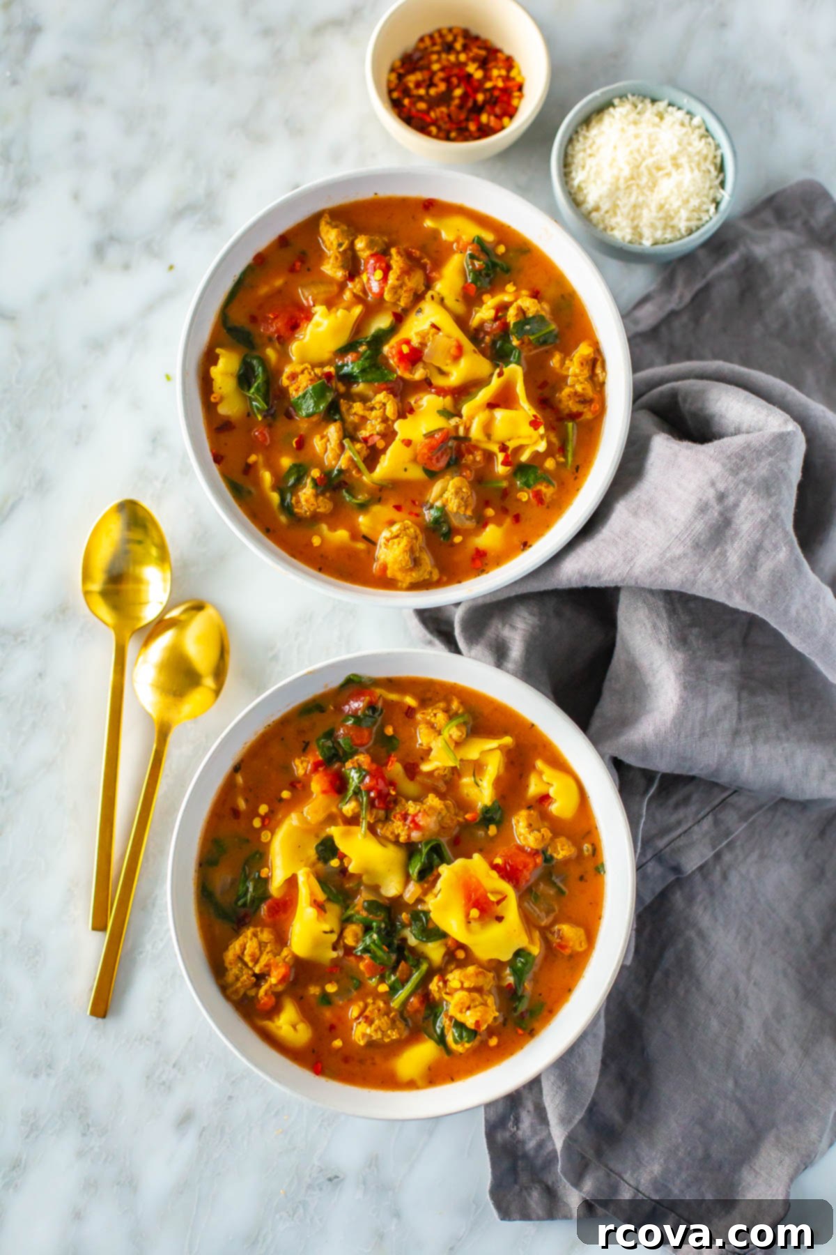 20 No-Fuss Slow Cooker Soup Recipes 13 Two steaming bowls of creamy crockpot tortellini soup with sausage, spinach, and parmesan.