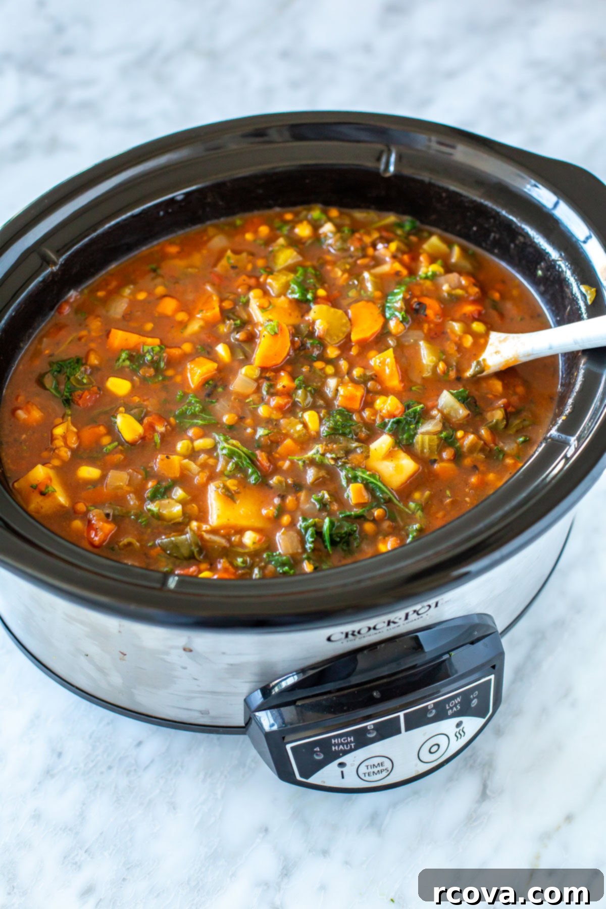 20 No-Fuss Slow Cooker Soup Recipes 15 An overhead shot of a slow cooker filled with vibrant, healthy vegetable soup.