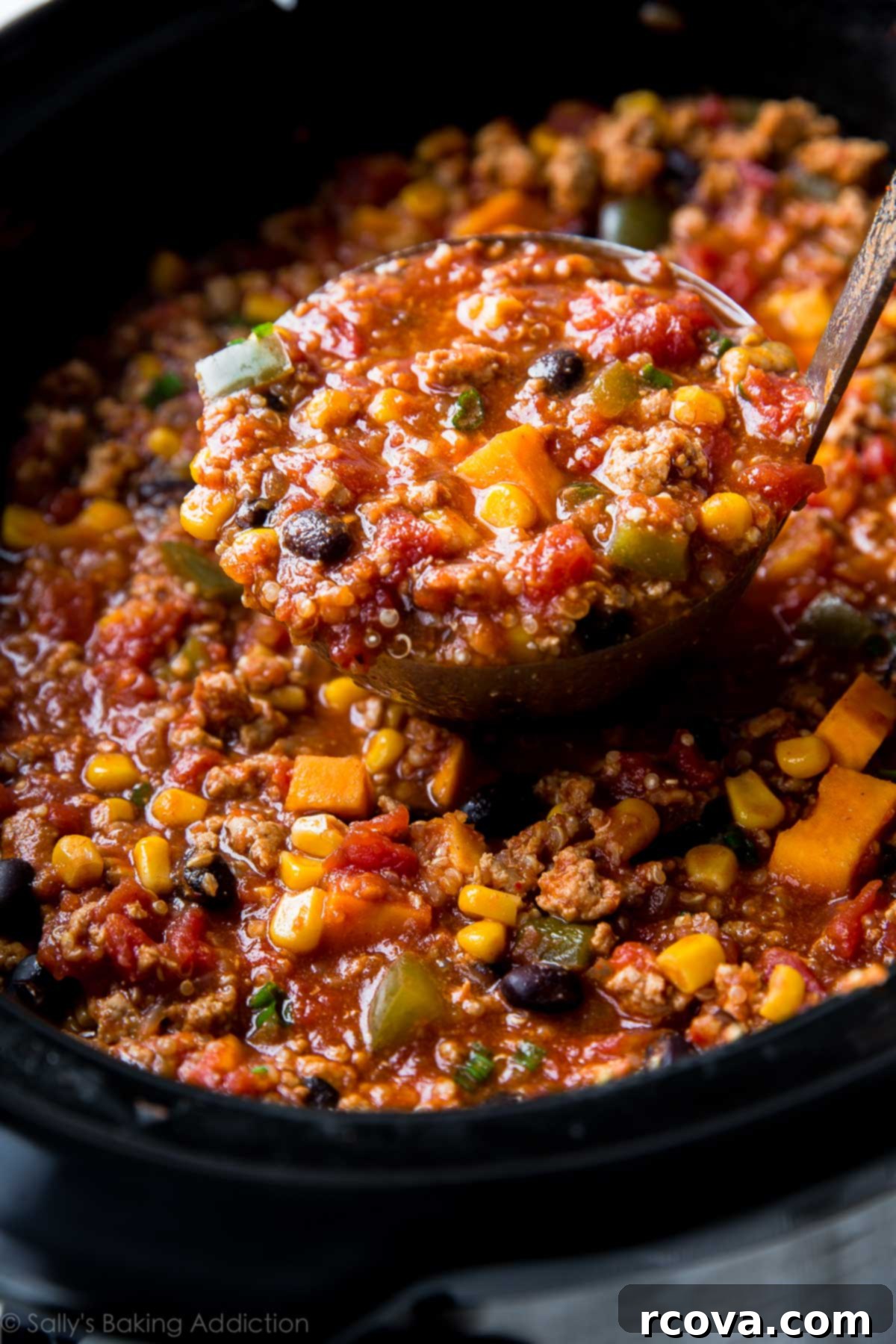 20 No-Fuss Slow Cooker Soup Recipes 23 Flavorful taco spice chili simmering in a crockpot, ready to be served with a ladle.