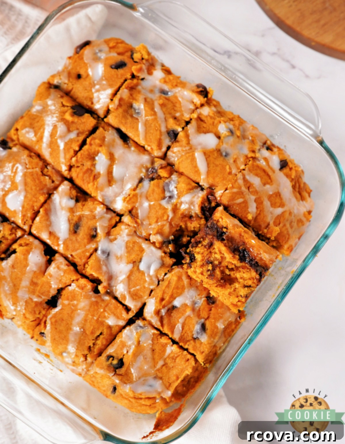 Cozy Autumn Pumpkin Chocolate Chip Bars 8 Easy pumpkin dessert bars with chocolate chips and white glaze, cut into neat squares on a serving plate.