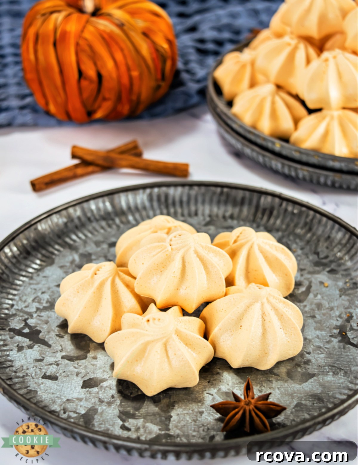 Pumpkin Spice Meringue Clouds 8 Close-up shot of a perfectly piped pumpkin meringue cookie, showcasing its crisp ridges, glossy finish, and vibrant orange color.