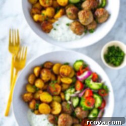 Oven-Roasted Greek Meatballs and Tangy Tzatziki 11 Two bowls of greek chicken meatballs with a side of potatoes, veggies and tzatziki.
