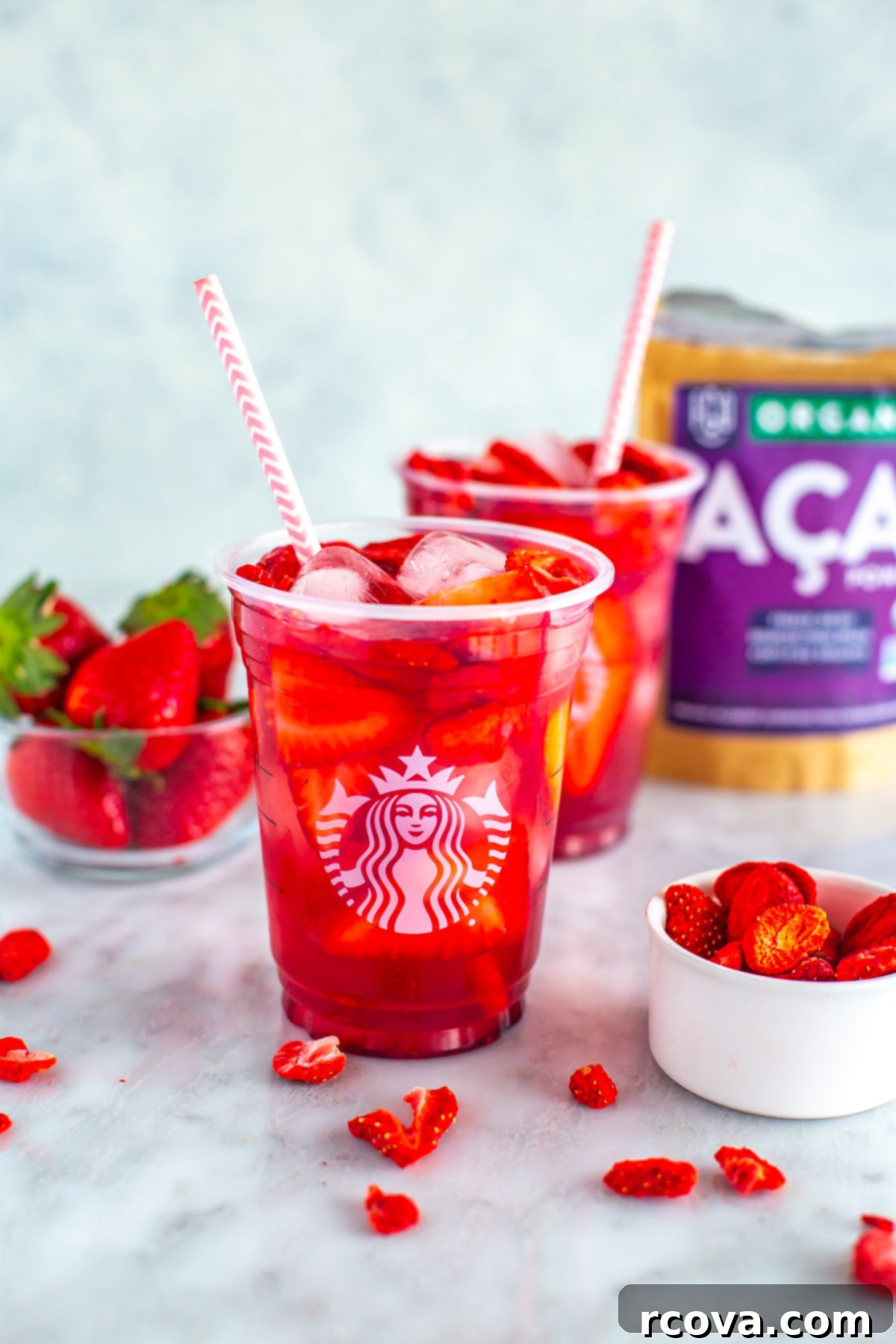DIY Starbucks Strawberry Acai Refresher 9 Two glasses of copycat Starbucks strawberry acai refreshers with ingredients placed behind them.