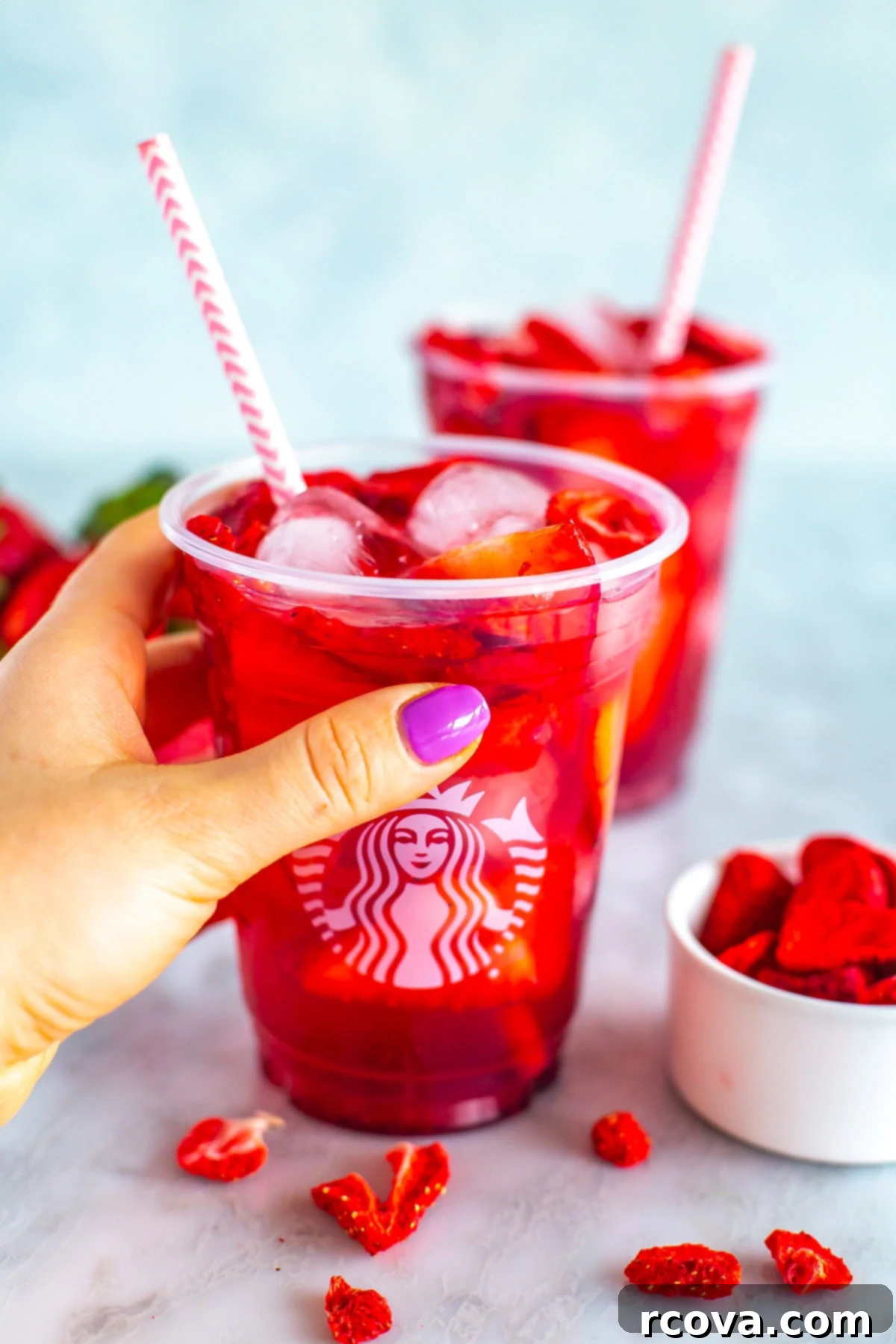 DIY Starbucks Strawberry Acai Refresher 10 A hand holding a copycat Starbucks strawberry acai refresher.