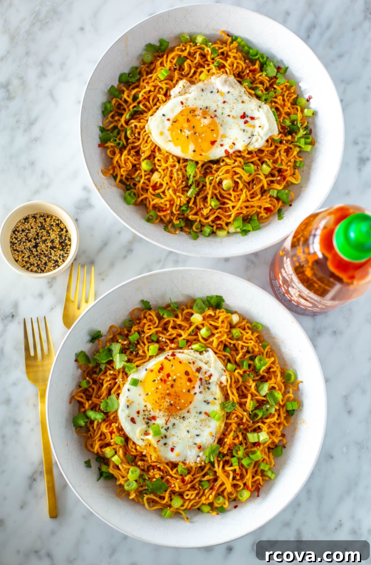 Quick Fiery Noodles 2 Two bowls of spicy noodles, each topped with a fried egg and green onions, presented invitingly.