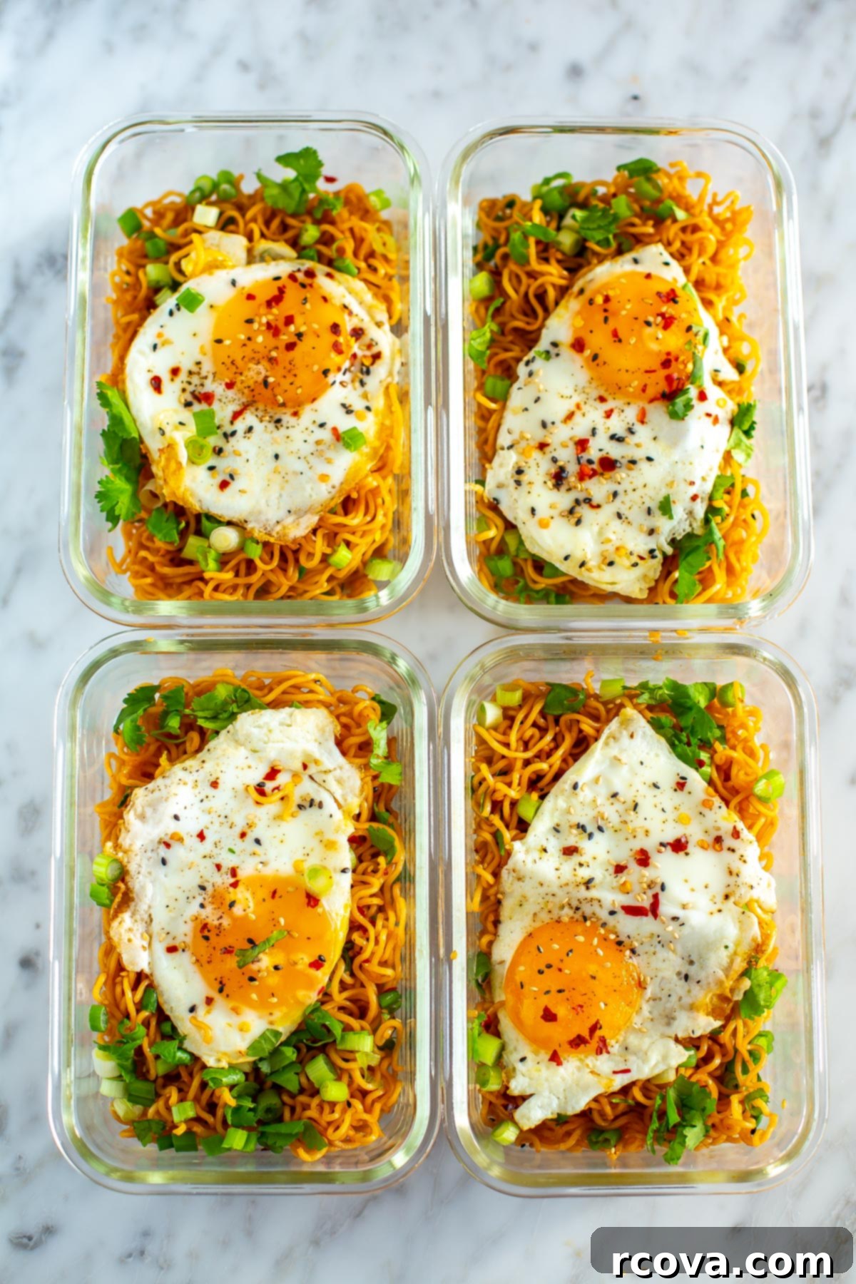 Quick Fiery Noodles 10 Four meal prep containers, each with a serving of spicy noodles topped with a fried egg, ready for grab-and-go meals.